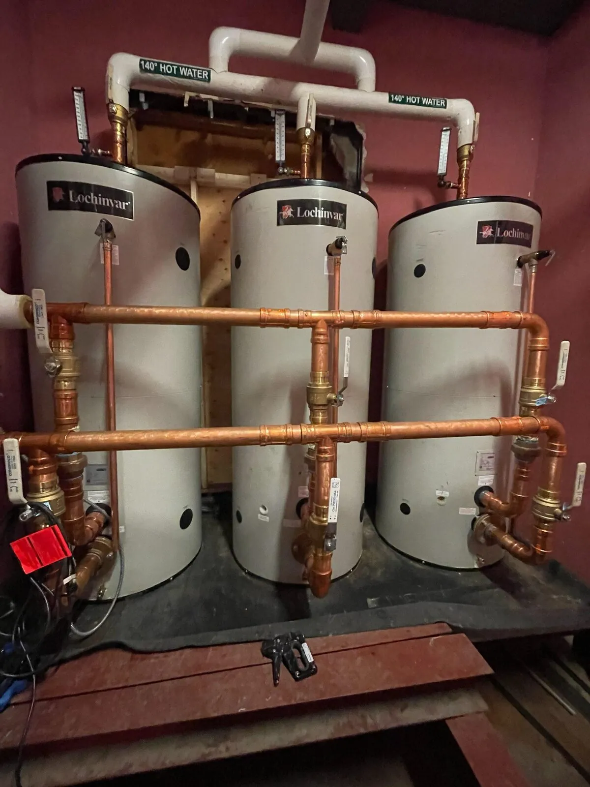 Three Lochinvar hot water storage tanks with insulated copper manifold piping