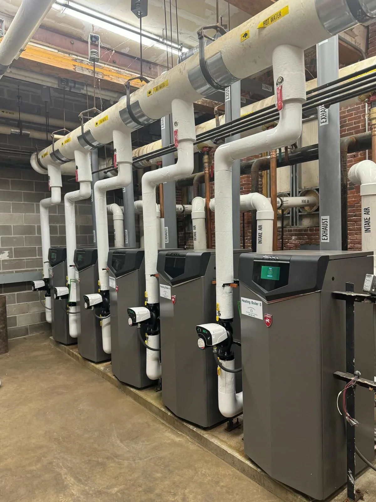 Boiler row with overhead insulated hot water and exhaust piping