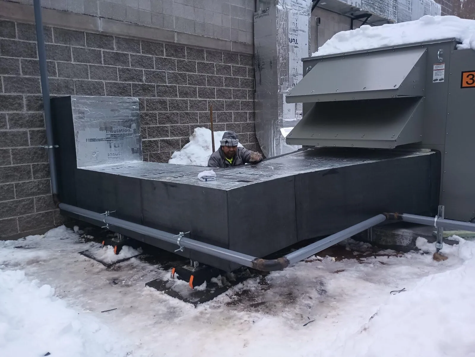 Outdoor mechanical curb insulated with rigid foam during winter retrofit