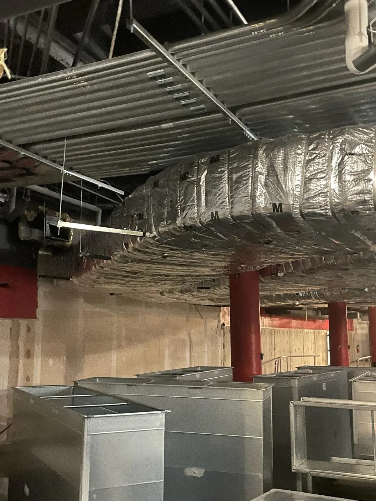 Insulated HVAC ductwork wrapped at commercial kitchen ceiling