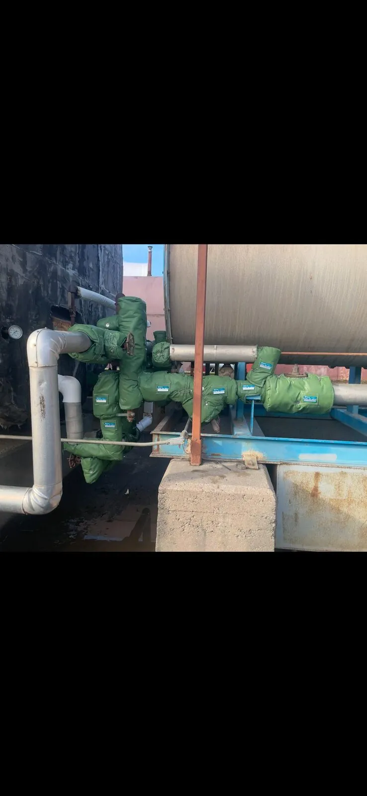 Green removable insulation jackets installed on rooftop pump and valve assembly